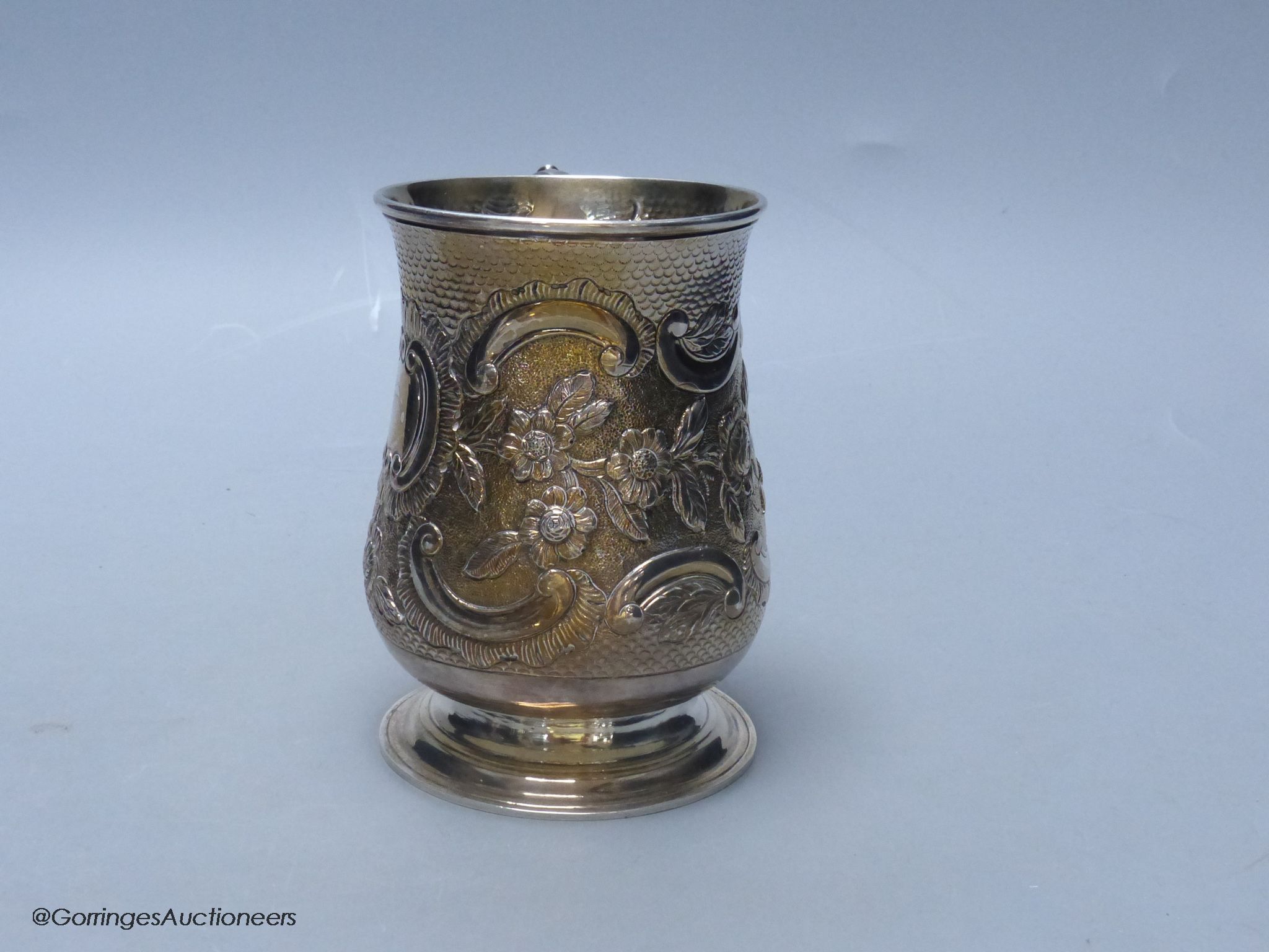 A George III silver baluster mug, with later embossed decoration, London, 1770, 12.7cm, 12.5 oz, indistinct maker's mark.